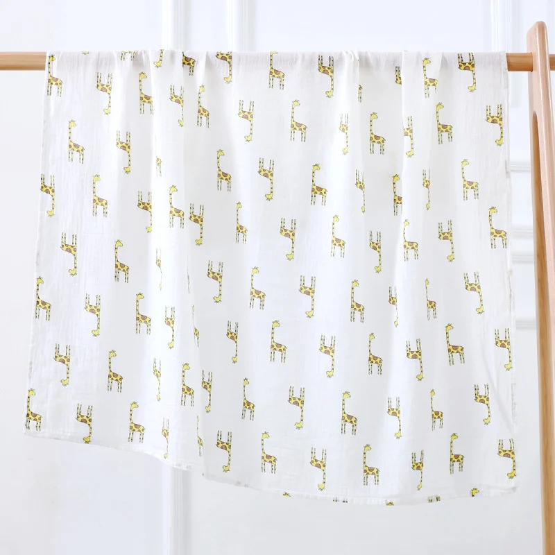 Swaddle blanket in cartoon pattern, wrapped around a newborn baby