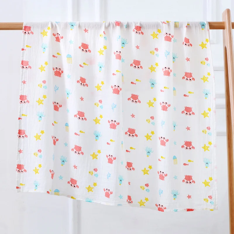 Swaddle blanket in floral pattern, laid out for tummy time on a soft mat