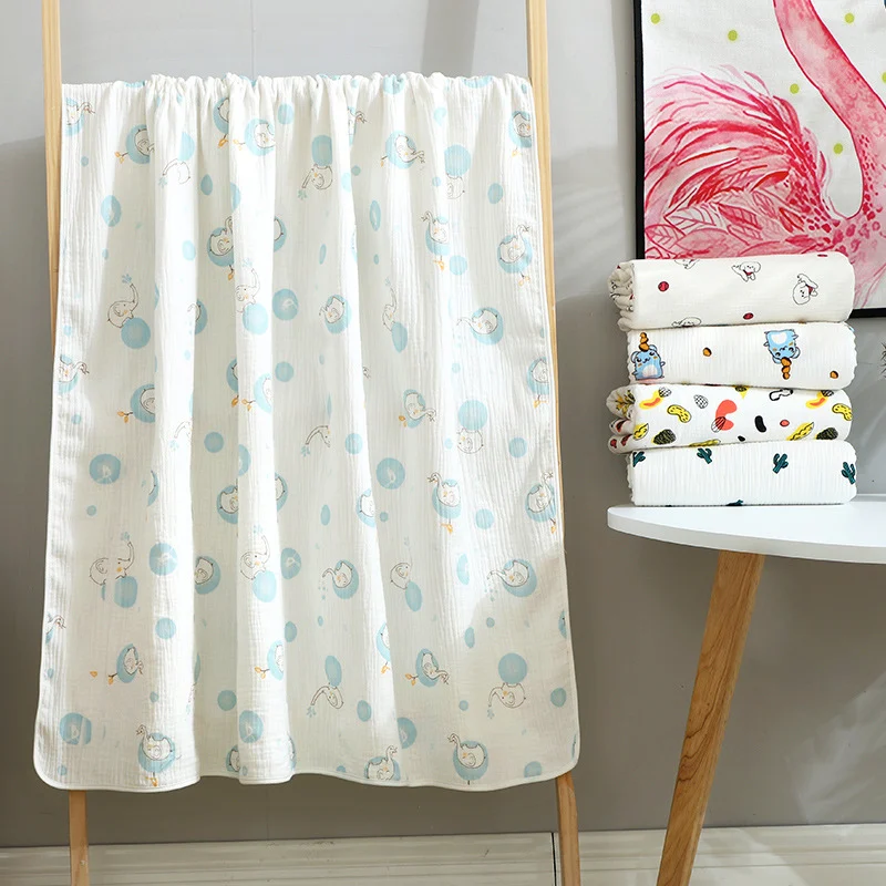 Green floral-patterned cotton muslin blanket folded in an OPP bag