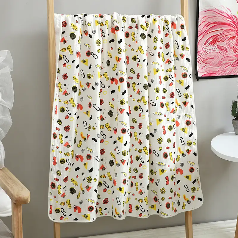 Orange floral-patterned cotton muslin blanket in a stack of 3