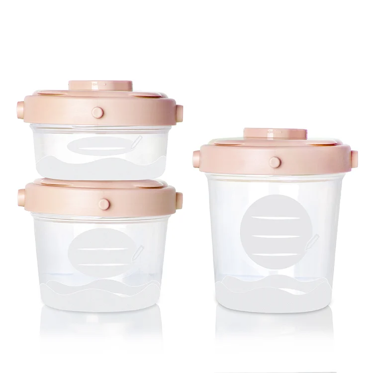 Pink and green baby food storage boxes stacked together with lids on