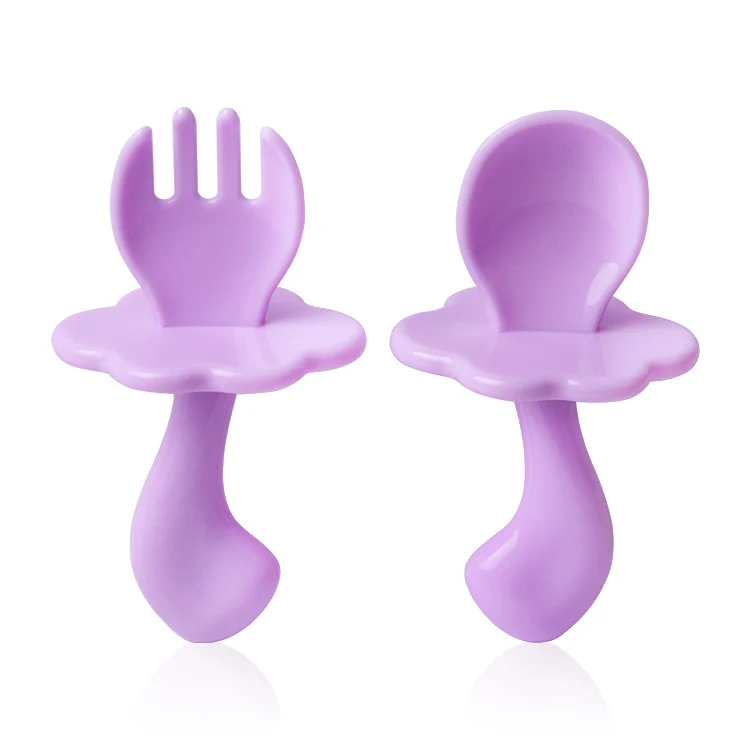 Light green baby feeding spoon and fork set from the side, showing handle thickness