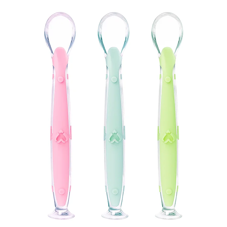 White silicone feeding spoon with suction cup on a white high chair tray