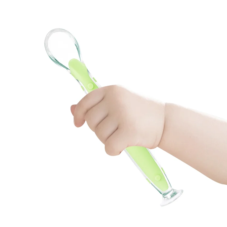 Spoon in use with a toddler holding it during feeding