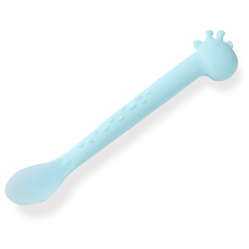 Soft silicone feeding spoon with textured base and easy-grip handle, shown in use