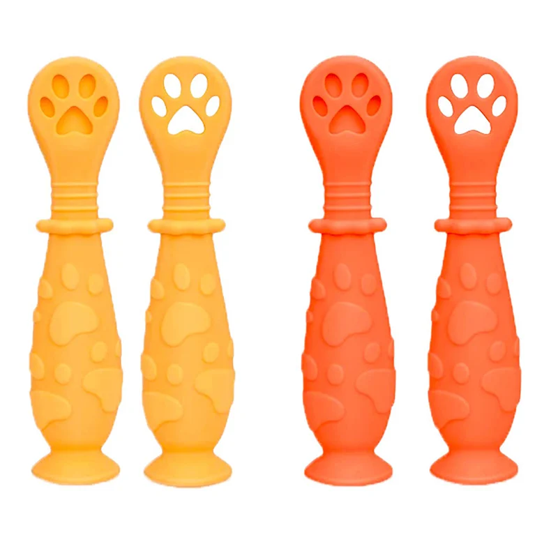 Pink silicone spoon with dog paw handle and suction base standing upright on a table