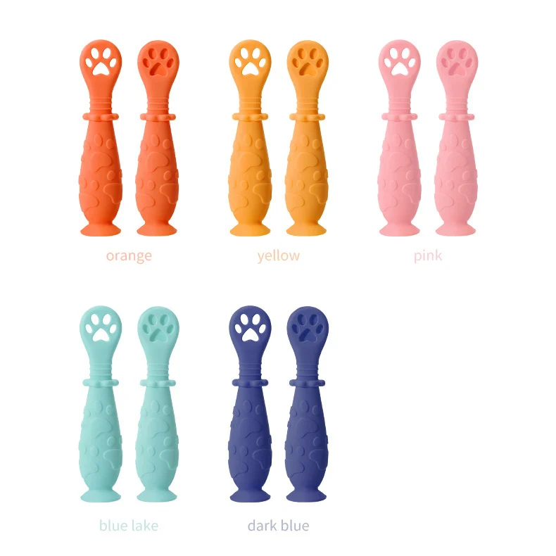 Blue silicone spoon with dog paw handle placed on a smooth surface with suction base engaged