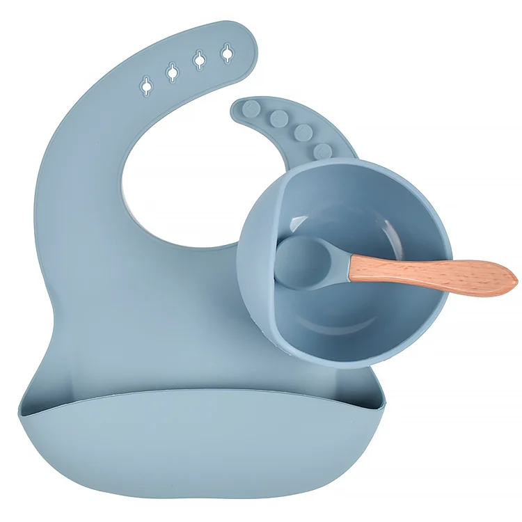 Adjustable silicone bib with four button fasteners, worn by a toddler
