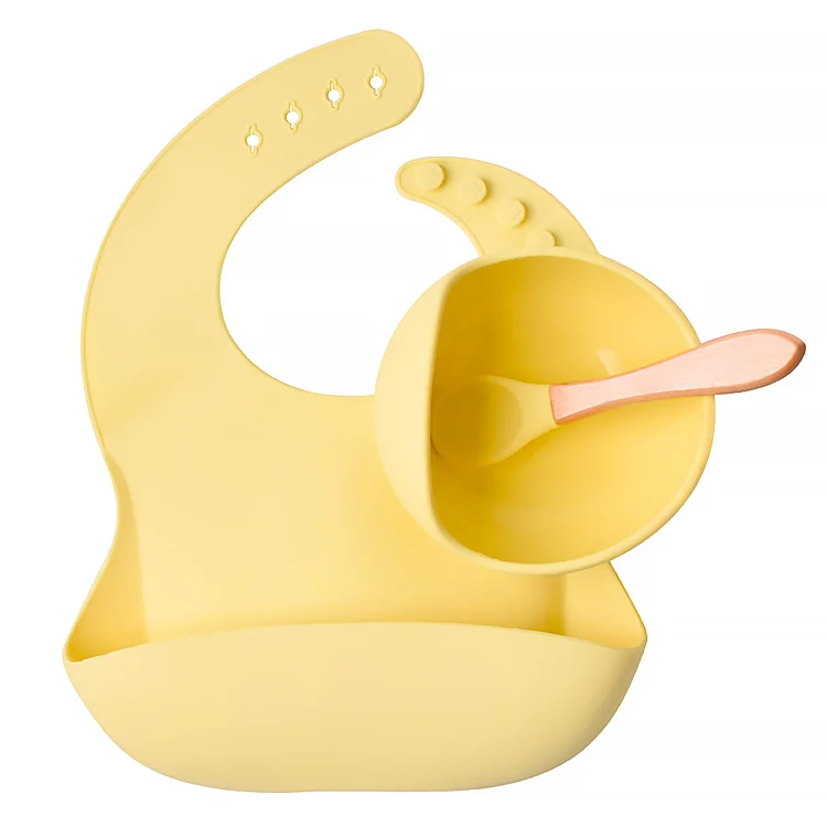 Baby spoon with organic bamboo handle and silicone tip, held by a small hand