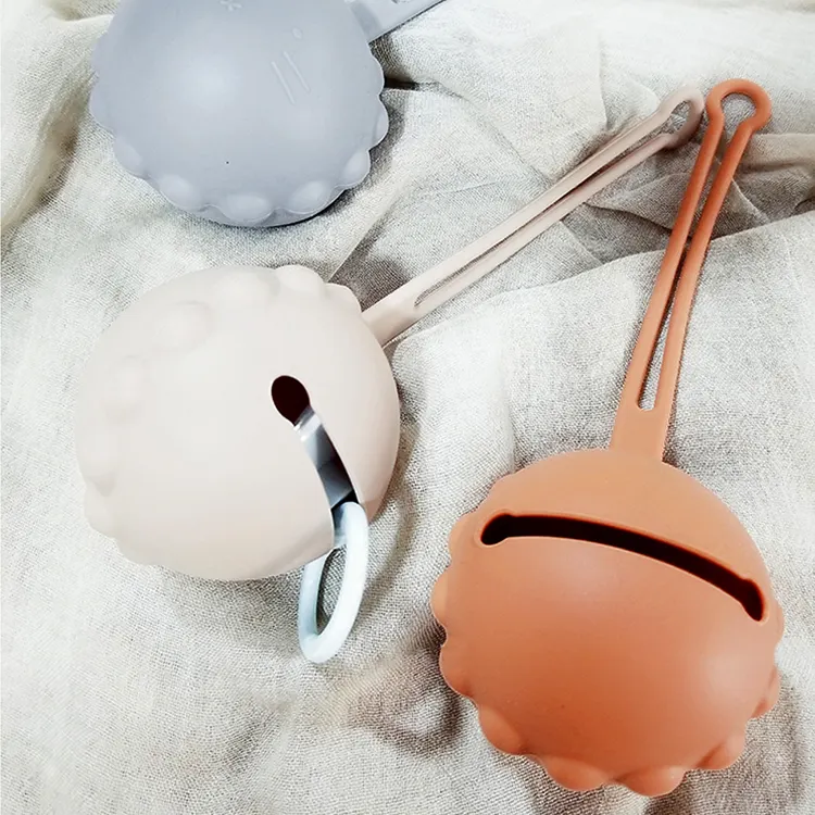 Green silicone pacifier holder lying flat on a surface