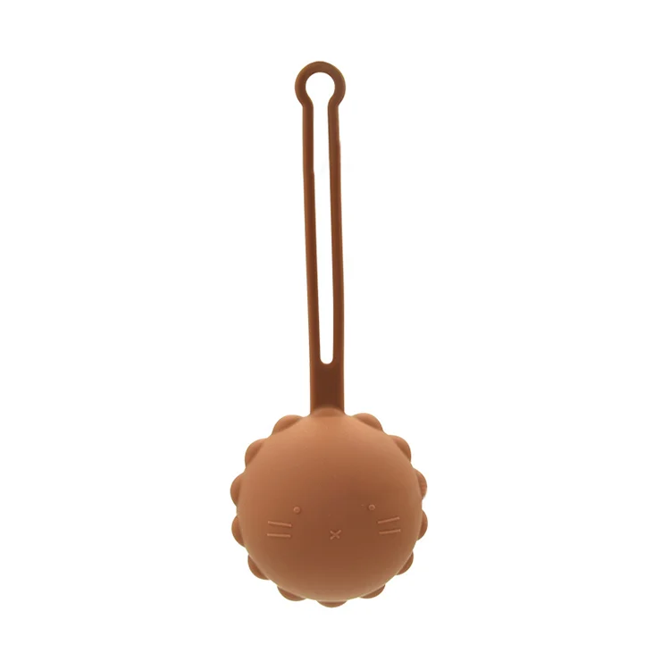 Silicone pacifier holder with strap looped through a diaper bag