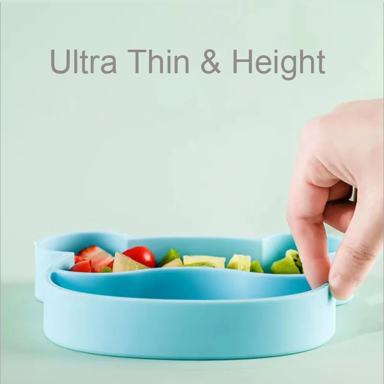 Bowl and utensils laid out on a table with a baby's hand reaching for the spoon