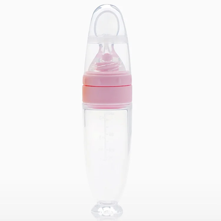 Soft silicone tip baby spoon feeder with suction cup base on a table