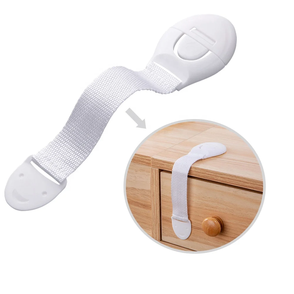 Drawer lock installed on a kitchen cabinet with the strap secured