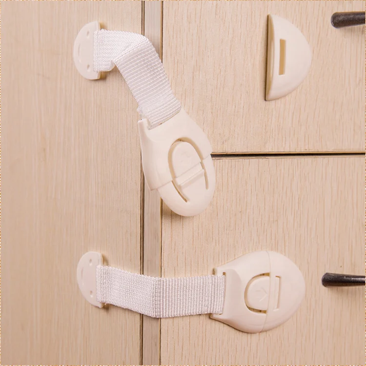 White adjustable strap drawer lock mounted on a cabinet drawer