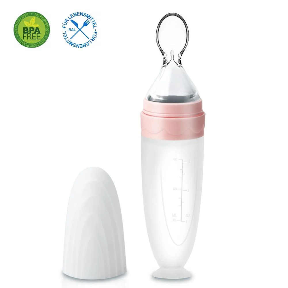 Blue silicone spoon feeder standing upright with suction cup on a table