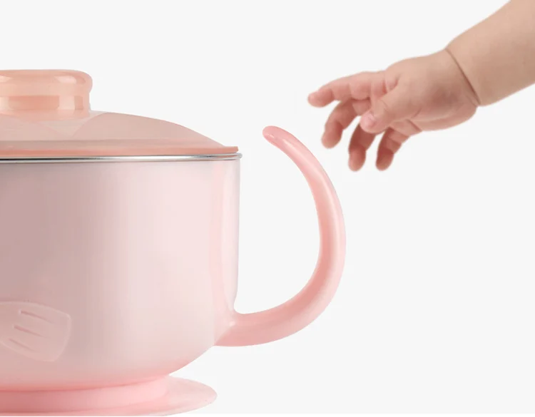 Baby spoon and fork with anti-skid grip and smooth edges, placed beside the bowl