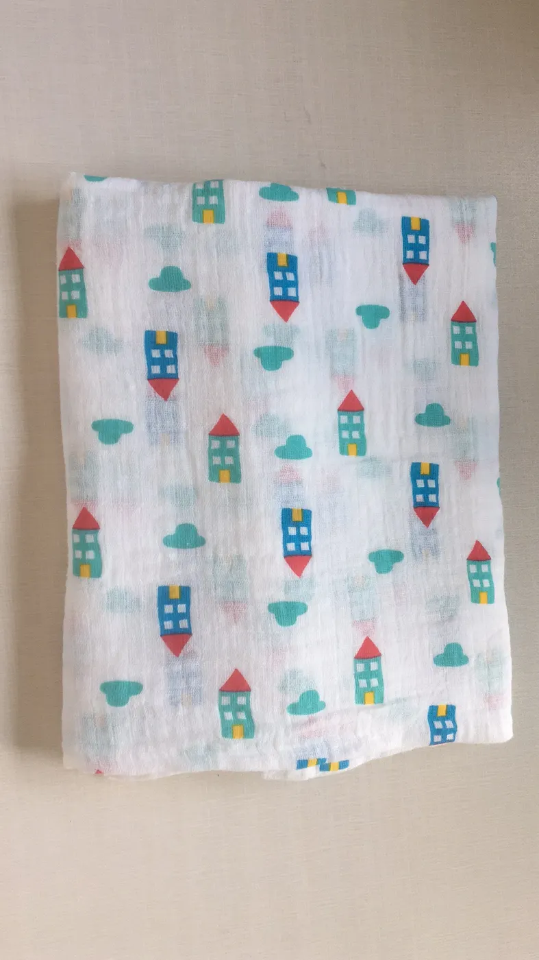 Colorful house pattern swaddle blanket, displayed in a retail box