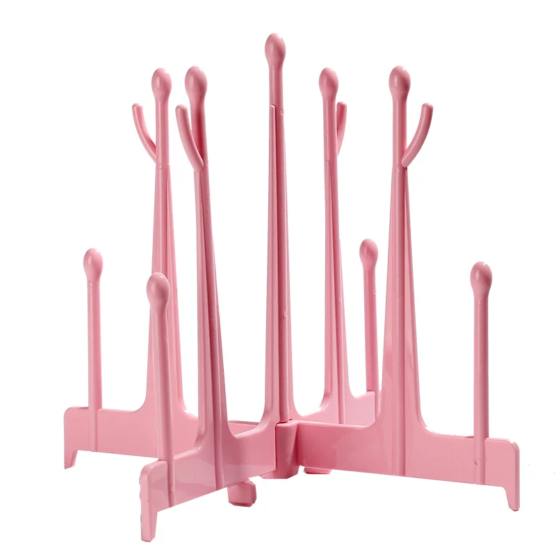 Pink baby bottle drying rack with bottles and accessories placed on branches