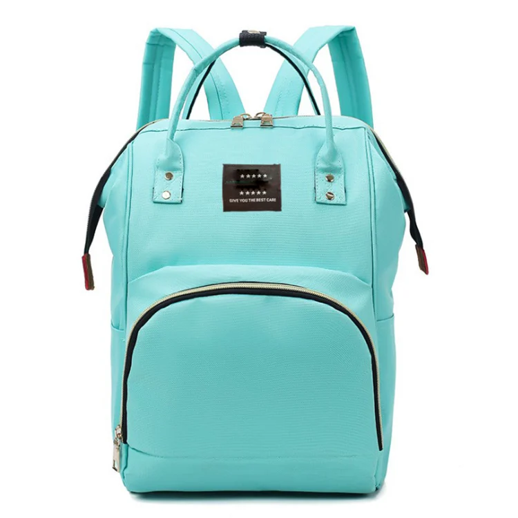 Diaper bag standing upright with a bottle and baby clothes inside