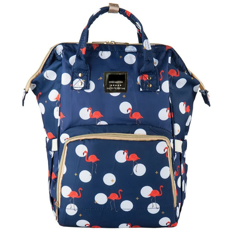 Green diaper bag open showing internal compartments for bottles, diapers, and wipes