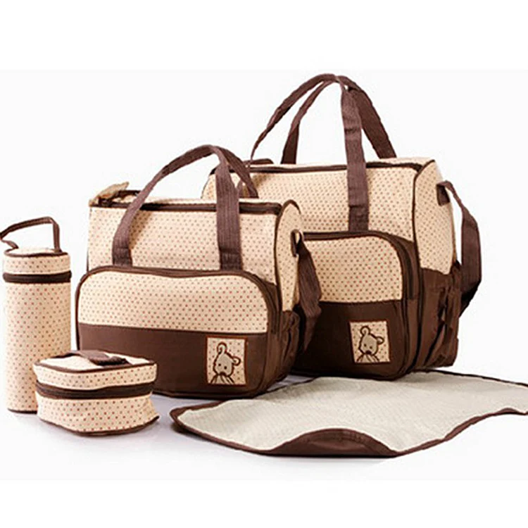 Diaper bag used as a change mat on a flat surface with baby items around