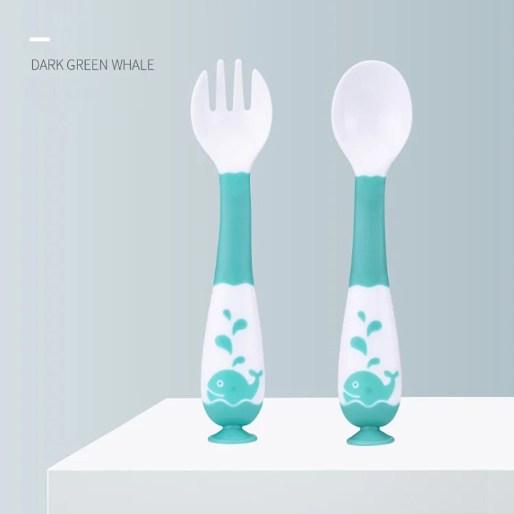 Pink bendable spoon and fork set standing upright on a table with suction cup base