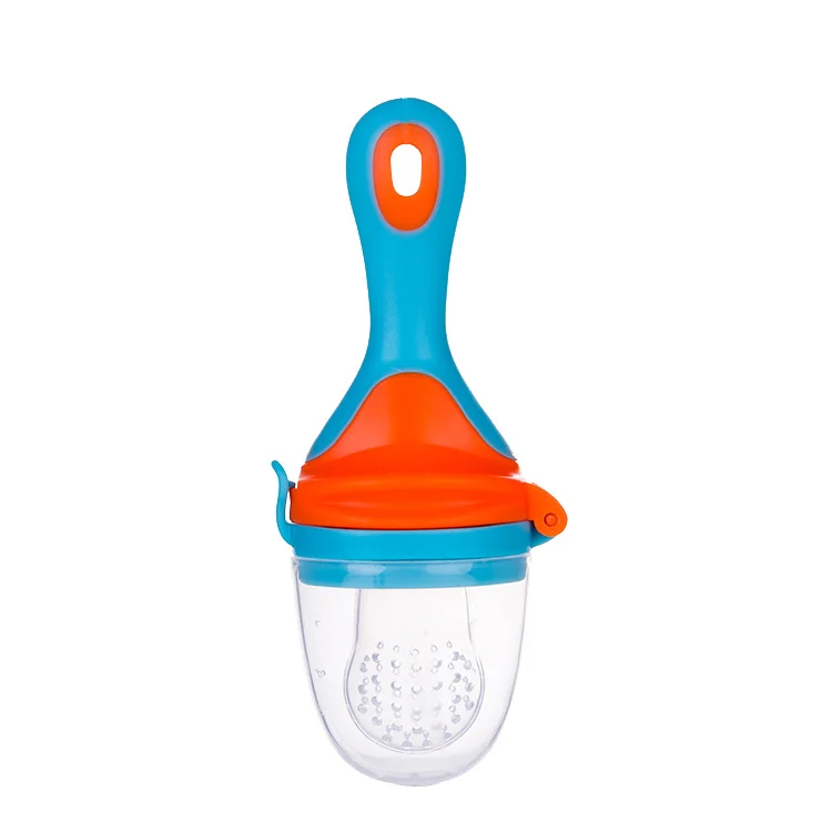 Green silicone feeder pacifier with three mesh inserts laid out beside it