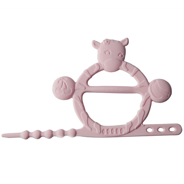 Cow-shaped silicone teething bracelet in pink, worn on a child's wrist