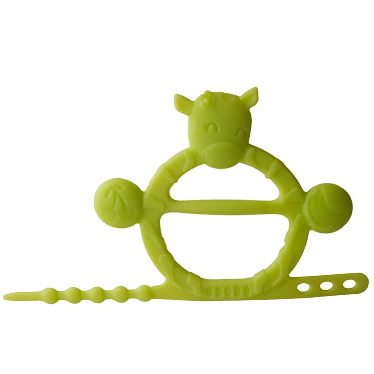 Cow-shaped teething bracelet in blue, lying flat with textured surfaces visible