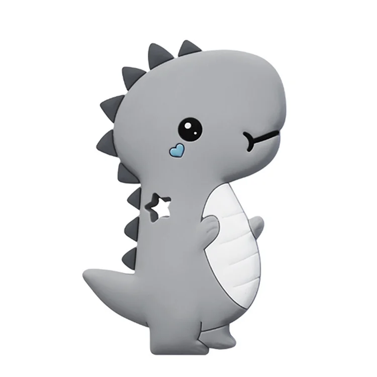 Green dinosaur teether toy held in hand, showing grip texture