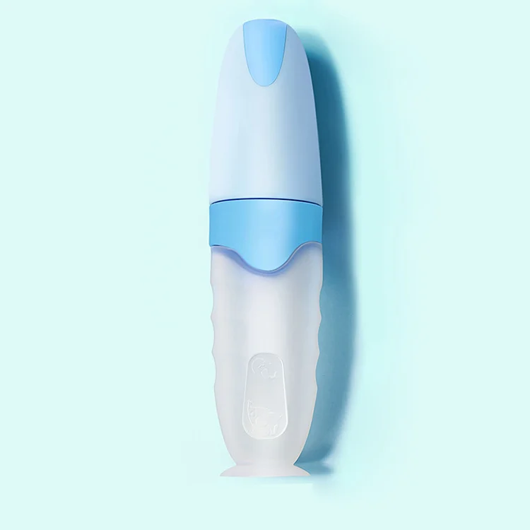 White silicone squeeze feeding bottle with built-in spoon and suction base standing upright