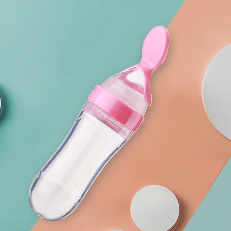 Baby feeding bottle with spoon head shown in use, dispensing food
