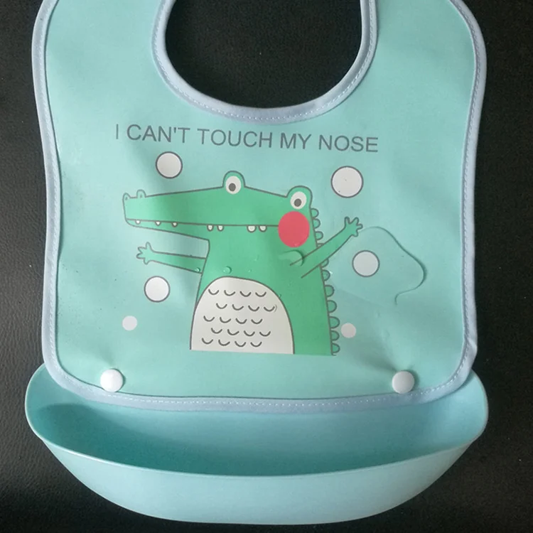 Green baby bib rolled up into its own tray for storage