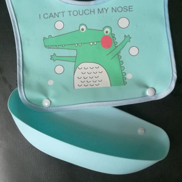 Baby bib in use, showing food caught in the tray during feeding