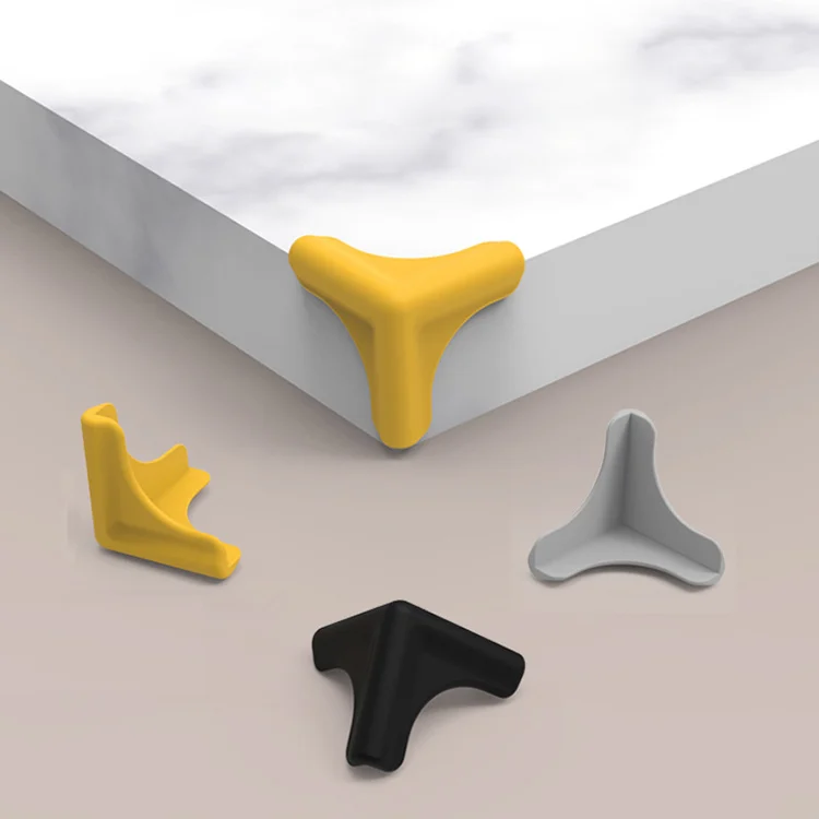 Yellow L-shaped silicone corner protector on a wooden table corner