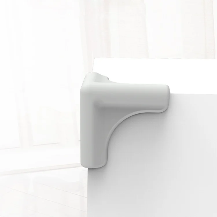Grey L-shaped silicone corner protector on a glass cabinet edge