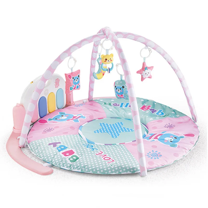 Green baby gym mat unfolded with piano at 360° angle and pendants attached