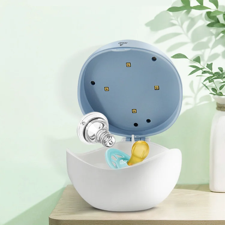 Sterilizer box placed next to a baby bottle and teether inside
