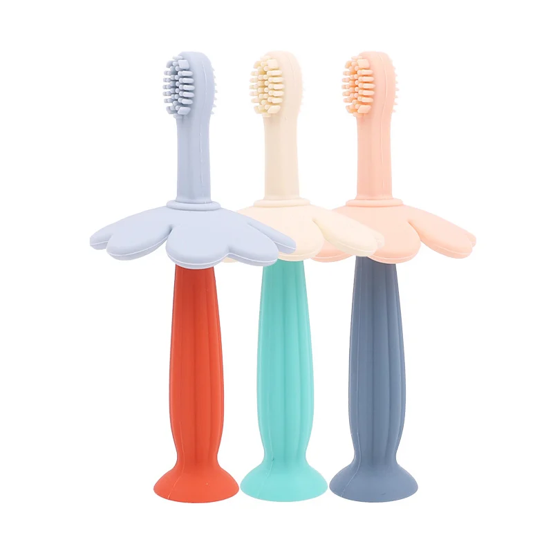 Pink 3 stage silicone toddler toothbrush with mushroom-shaped handle and storage box