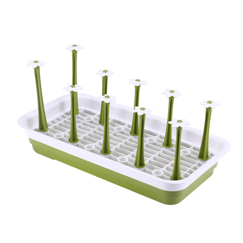Blue baby bottle drying rack with central drop hole, placed on a kitchen counter