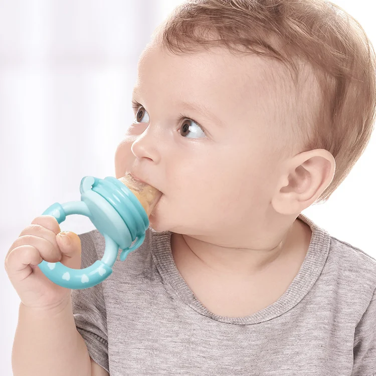 Feeder placed in a baby's hand, demonstrating easy grasp and self-feeding