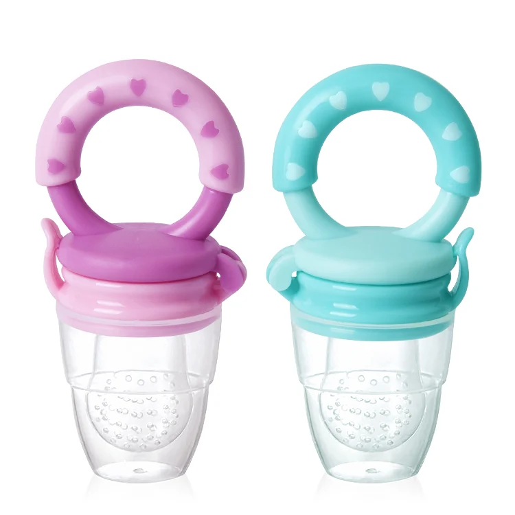 Baby using the feeder to suck on frozen fruit pieces, showing grip and feeding action