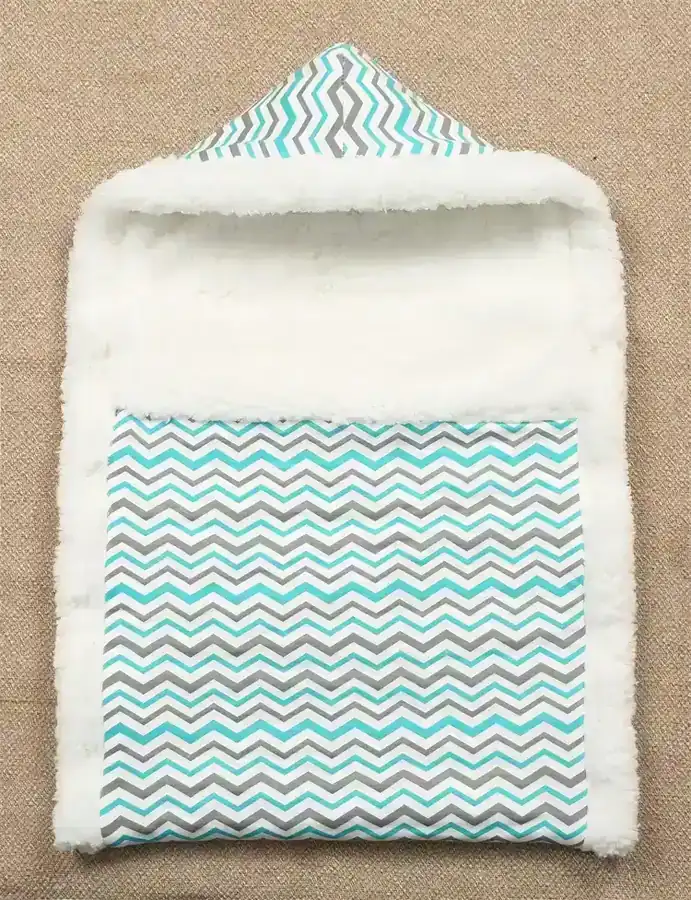 Stroller wrap sleeping bag placed over a baby stroller seat