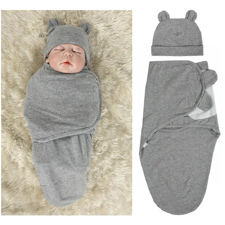 Blue cotton stretchy baby swaddle blanket with hat, wrapped around a newborn