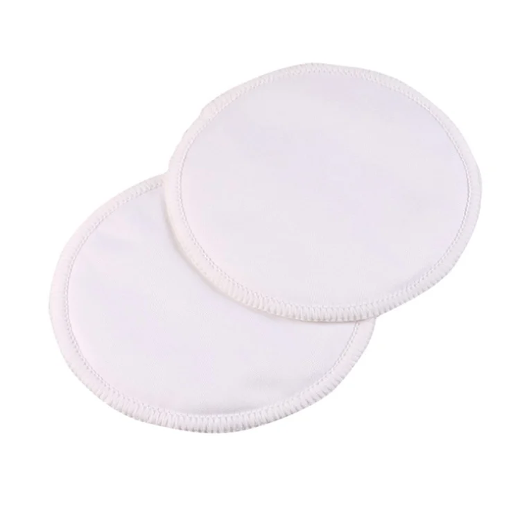 Nursing pad laid on a flat surface with a measuring tape beside it