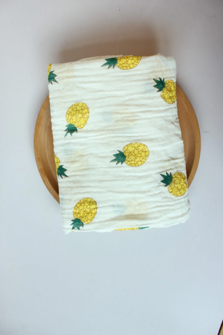Pineapple pattern swaddle blanket, shown in a baby photography setup