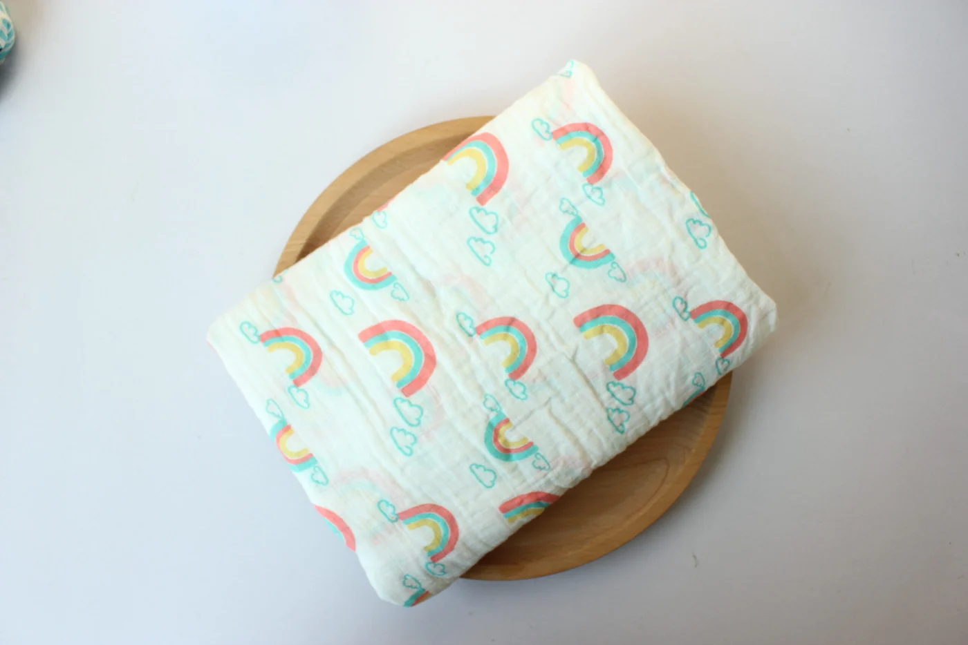 Rainbow pattern swaddle blanket, laid flat with soft lighting