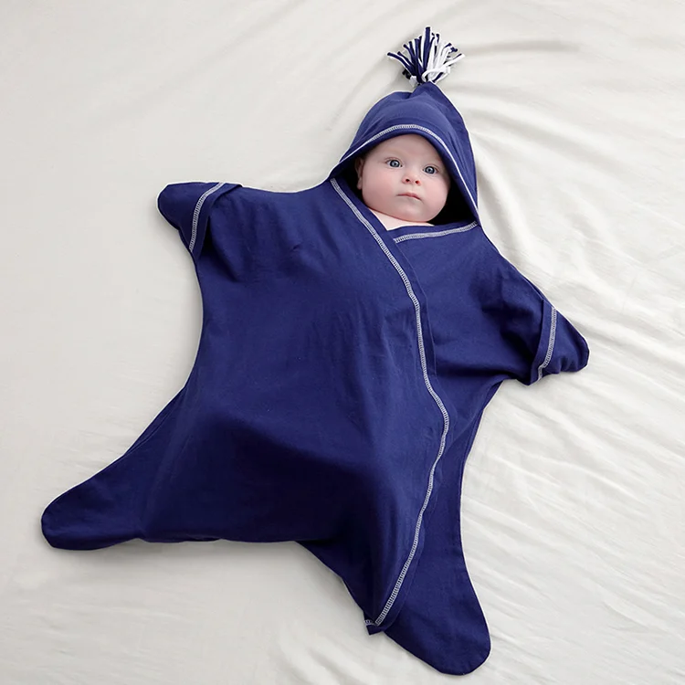 Star-shaped baby sleep bag in white cotton, standing upright with lace-up closure visible