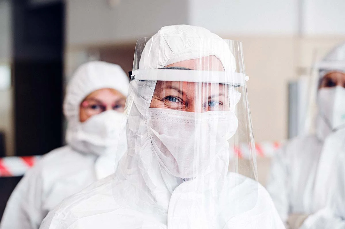 Full protective suit, mask and face shield worn in a PPE production environment